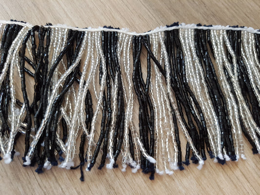 Perlenkette mit schwarz/weißen Schnüren und vielen Perlen

 60cm lang, Stränge 20cm lang