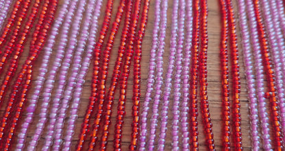 Perlenkette mit Strängen aus rot rosa Perlen 